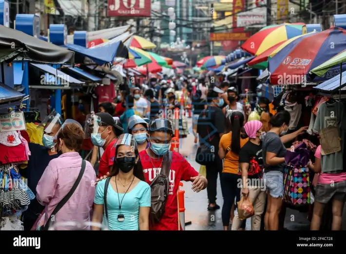 manila-philippines-20th-mar-2021-people-wearing-protective-masks-are-seen-at-a-busy-street-in-manila-the-philippines-march-20-2021-the-philippines-reported-on-saturday-7999-new-covid-19-infections-the-highest-daily-tally-since-the-o.jpg